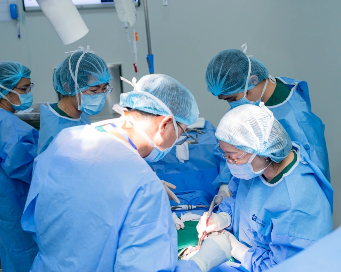 Cắt bán phần dây thanh, bảo tồn giọng nói cho người ung thư Giáo sư Chung Thủy (ngoài cùng bên phải) đang phẫu thuật cho ông Sang. Ảnh: Bệnh viện Đa khoa Tâm Anh