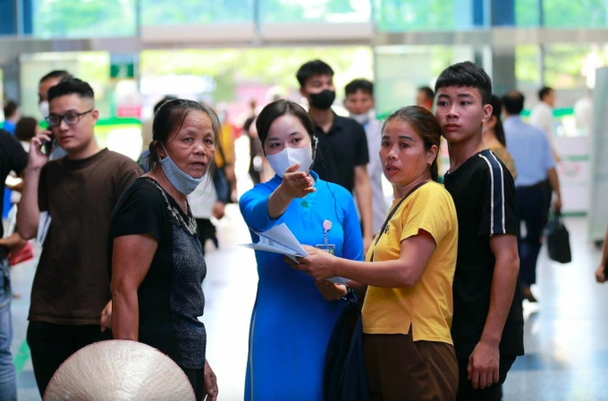 Nhân viên y tế Bệnh viện Bạch Mai hướng dẫn người dân làm thủ tục khám chữa bệnh. Ảnh:Thế Anh