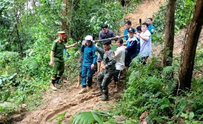 Các lực lượng dùng võng khiêng sản phụ qua điểm sạt lở ở xã Sơn Tây, chiều 30/10. Ảnh: Trà Giang