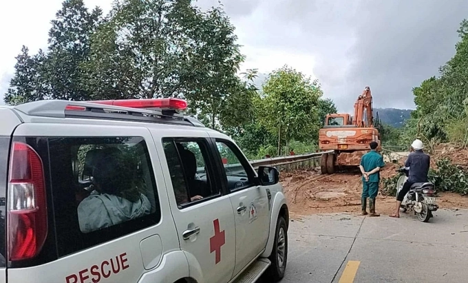Xe xúc dọn đường để xe cấp cứu chở sản phụ qua điểm sạt lở. Ảnh: Trà Giang