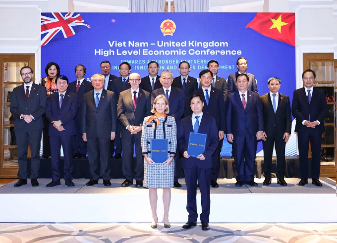 Tổng Bí thư Tô Lâm, Đặc phái viên Thương mại của Chính phủ Anh Matt Western chứng kiến ông Ngô Chí Dũng, Chủ tịch Hội đồng quản trị kiêm Tổng Giám đốc Công ty Vắc xin Việt Nam VNVC và bà Kaja Natland, Phó Chủ tịch cấp cao GSK vùng châu Á - Thái Bình Dương, khu vực quốc tế, trao văn kiện hợp tác. Ảnh: Hoàng Thống Nhất