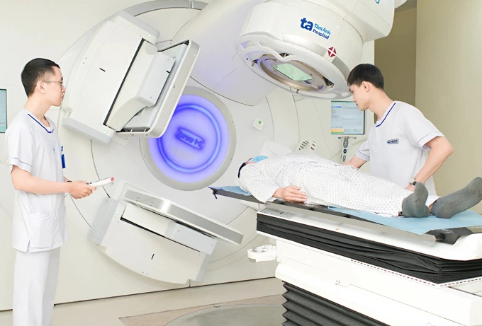 Kỹ thuật viên chuẩn bị, điều chỉnh tư thế nằm đúng cho người bệnh trước xạ trị. Ảnh minh họa: Bệnh viện Đa khoa Tâm Anh