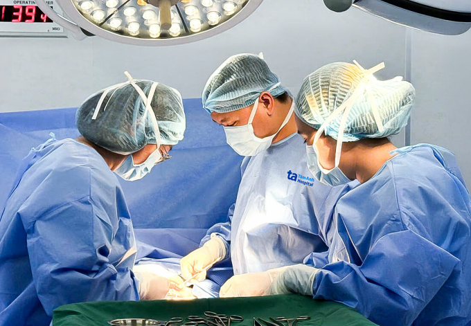 Bác sĩ Quang Nhật (giữa) phẫu thuật lấy khối u lạc nội mạc ở vết sẹo mổ lấy thai cho chị Thúy. Ảnh: Tuệ Diễm.