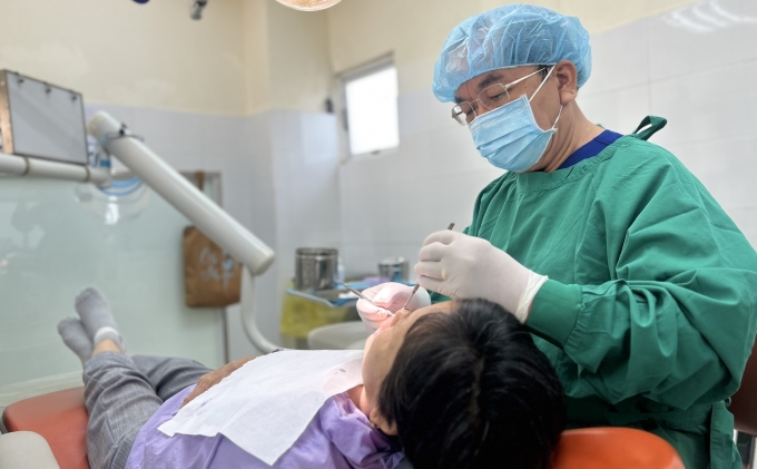 BS.CK2 Nguyễn Anh Ninh, Trưởng Khoa Lão Nha, Bệnh viện Răng Hàm Mặt Trung ương, thăm khám người bệnh. Ảnh: Bệnh viện cung cấp