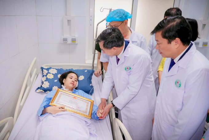 Điều dưỡng Trang nhận bằng khen của Bộ Y tế khi đang điều trị trên giường bệnh hôm 28/10. Ảnh: Hùng Lê