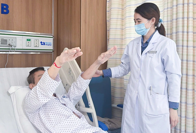 Bác sĩ Hạnh Tiên đang kiểm tra khả năng vận động cho ông Trung sau hai ngày điều trị. Ảnh: Bệnh viện Đa khoa Tâm Anh