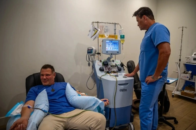 Cơn sốt lọc máu chống lão hóa của giới siêu giàu Tiến sĩ Keith Smigiel (phải) đang giám sát quy trình thực hiện cho Van Es tại phòng khám của mình. Ảnh: NY Post