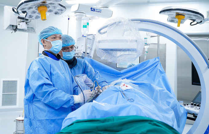 Hai lần nội soi tán sạch sỏi thận Bác sĩ Cương (trái) tán sỏi thận qua da cho bà Trinh. Ảnh: Bệnh viện Đa khoa Tâm Anh