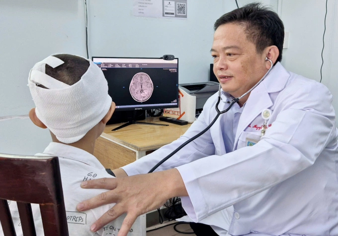 Ca mổ giúp bé trai 13 tuổi thoát co giật Bác sĩ Nguyễn Thành Đô thăm khám cho Long sau phẫu thuật. Ảnh: Lê Phương