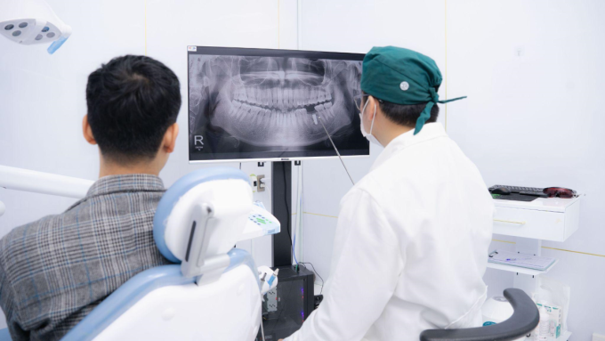 Kiều bào về nước trồng răng implant dịp cận tết tại SGC Bác sĩ thăm khám răng cho bệnh nhân. Ảnh: SGC