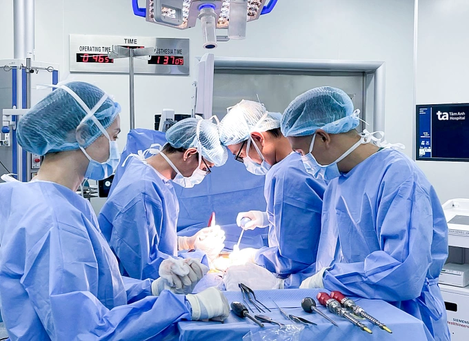 Cong vẹo cột sống có tái phát không? Bác sĩ Sơn (thứ hai bên phải) phẫu thuật điều trị cột sống cong vẹo cho người bệnh. Ảnh: Bệnh viện Đa khoa Tâm Anh