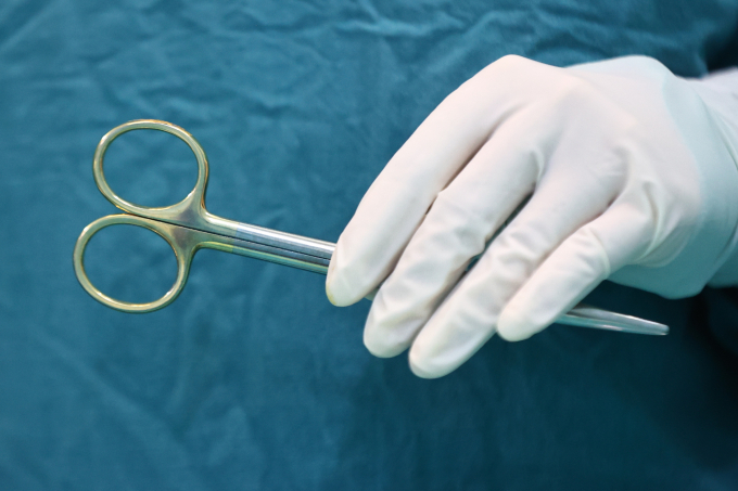 Bé 2 tuổi bị chó nhà cắn rách môi và vùng tai Nhân viên y tế điều trị bệnh nhân. Ảnh: Quỳnh Trần