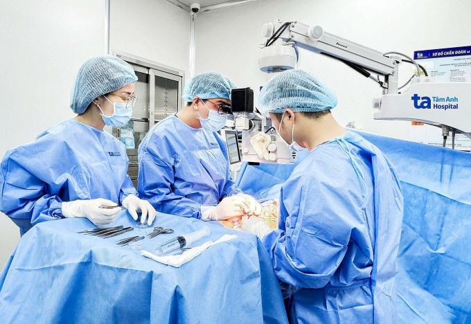 Cạn kiệt tinh trùng ở tuổi 30 Bác sĩ Vinh (giữa) cùng êkíp vi phẫu micro-TESE tìm thấy tinh trùng cho người bệnh. Ảnh: Hoài Thương