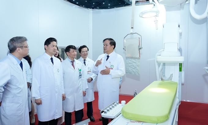 Bệnh viện Bạch Mai vận hành dàn máy móc giá hơn 1.000 tỷ đồng PGS Đào Xuân Cơ (trái) giới thiệu hệ thống máy móc vừa được lắp đặt tại Bệnh viện Bạch Mai. Ảnh: Thành Dương