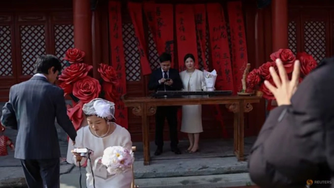 Phụ nữ Trung Quốc 'lạnh nhạt' với tiền thưởng cưới Các cặp mới cưới chụp ảnh tại một ngôi đền ở Bắc Kinh hôm 28/10. Ảnh: Reuters/Tingshu Wang