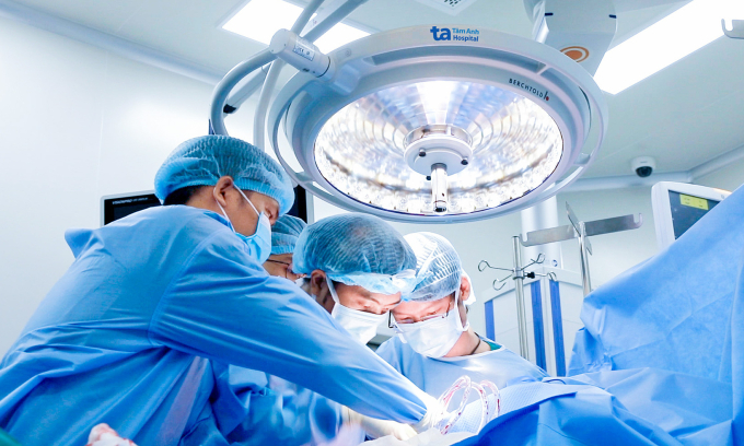 Tái tạo dây chằng sau hai lần đứt Bác sĩ Dương (phải) lấy gân tứ đầu nông cho người bệnh. Ảnh: Bệnh viện Đa khoa Tâm Anh