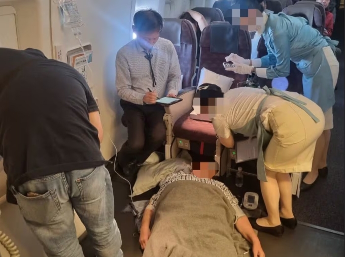 Giáo sư Kim Jeong-hwan cùng các đồng nghiệp giúp cấp cứu bệnh nhân trên chuyến bay từ Hàn Quốc đến Philippines hôm 24/3. Ảnh: Facebook Kim Jeong-hwan