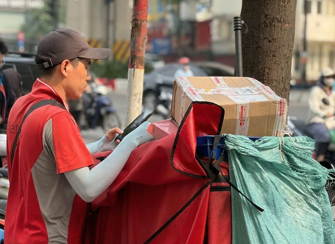 Một shipper đợi khách nhận hàng buổi trưa tại TP HCM, ngày 8/4. Ảnh: Mỹ Ý