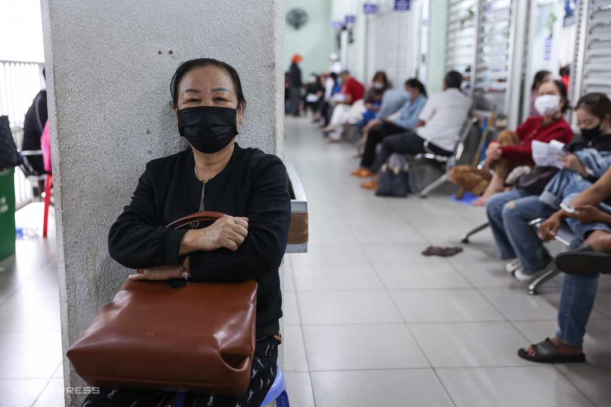 With seating rows completely filled, 65-year-old Thu leaned against a pillar waiting for her turn outside the examination room after an early morning arrival.